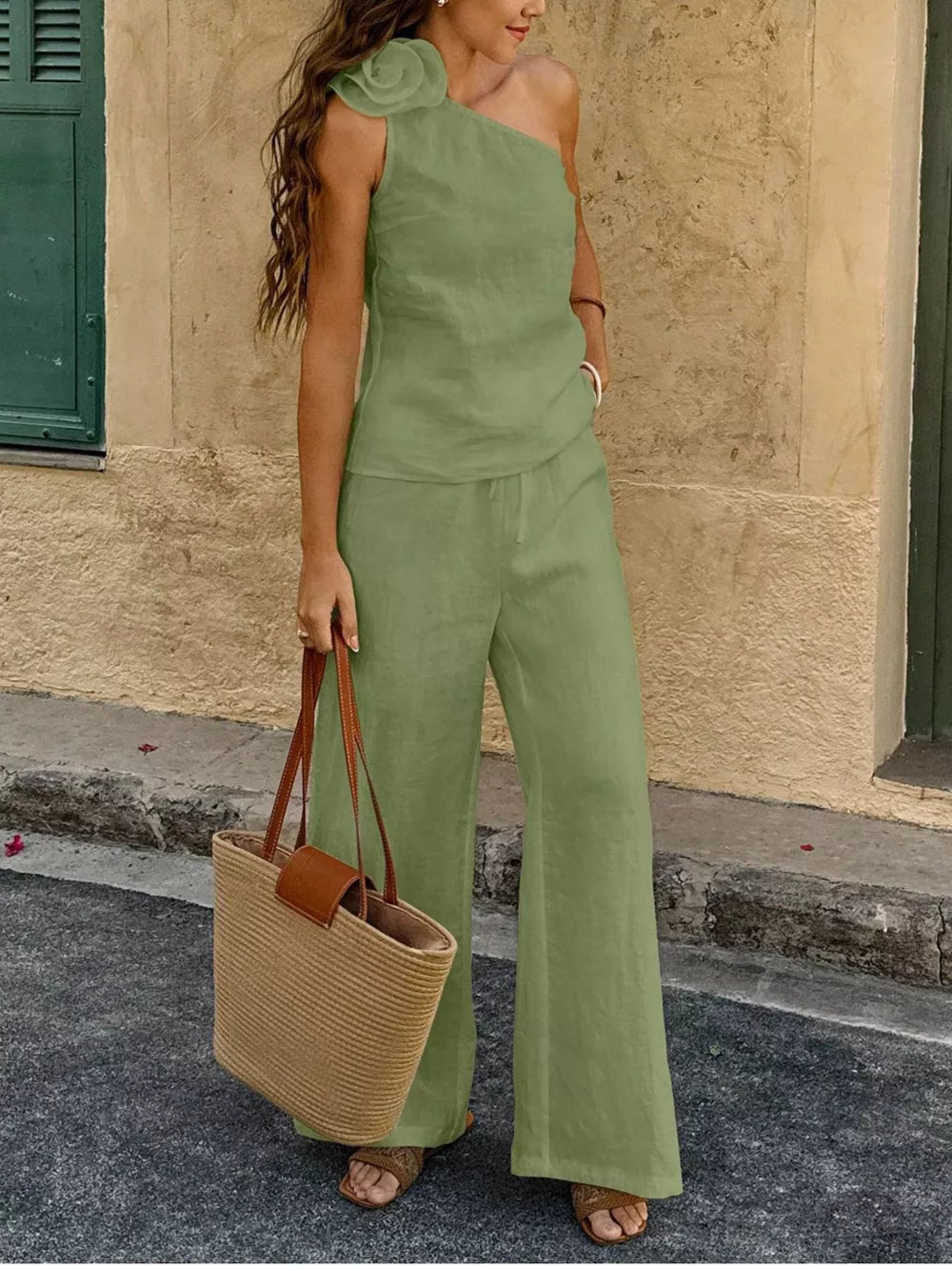 Mint green cotton one-shoulder top with floral embellishment and wide-leg pants.