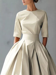 Chic white A-line midi dress with a pleated skirt and three-quarter sleeves.