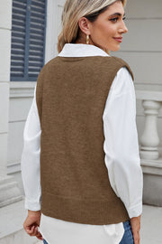 Taupe acrylic knit vest with button front and shoulder detail, worn over a white shirt.