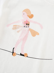 White cotton baby tee with a playful ballerina graphic on a tightrope.
