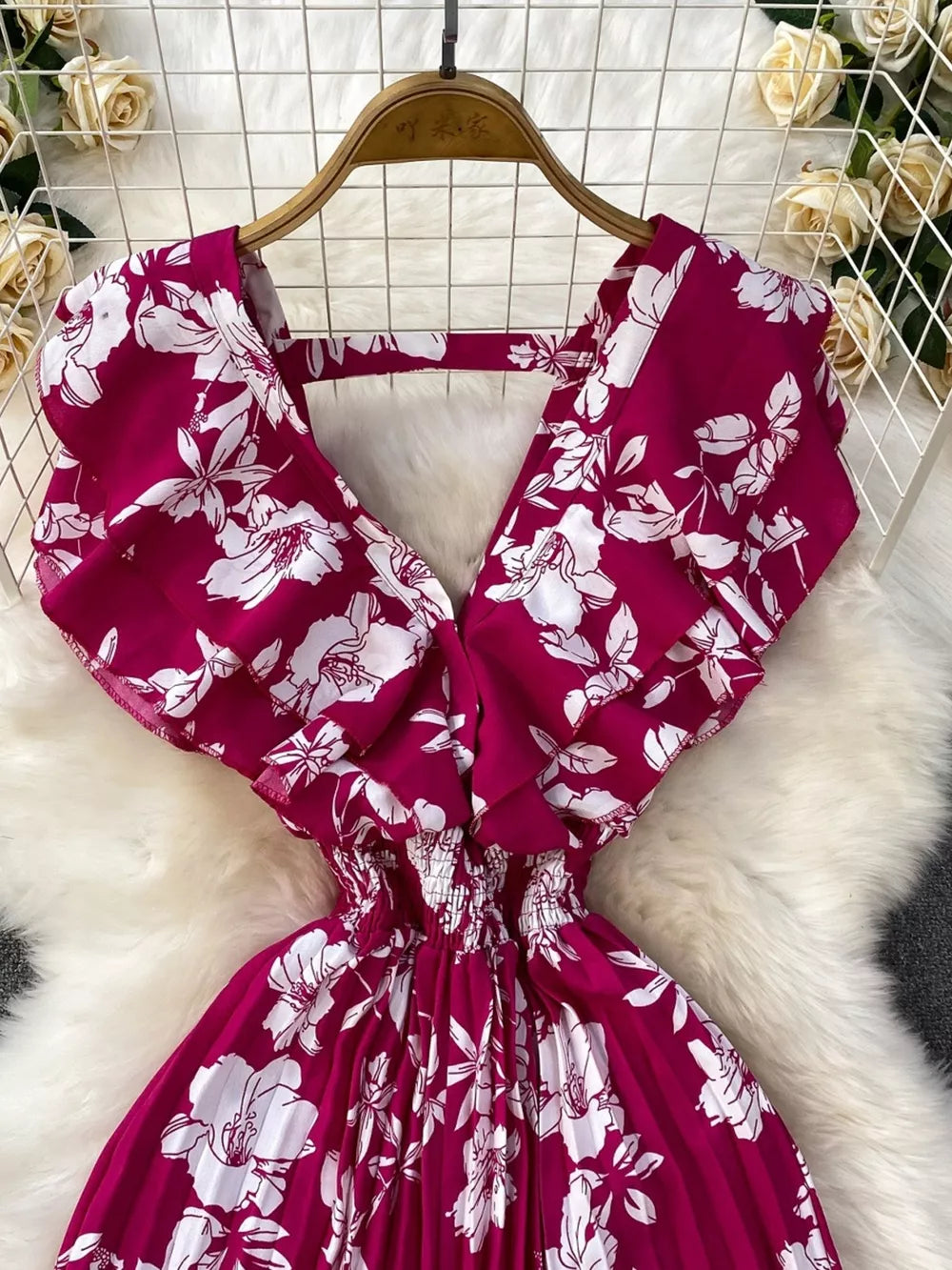 Rose Red floral print romper with ruffled sleeves and smocked waist.