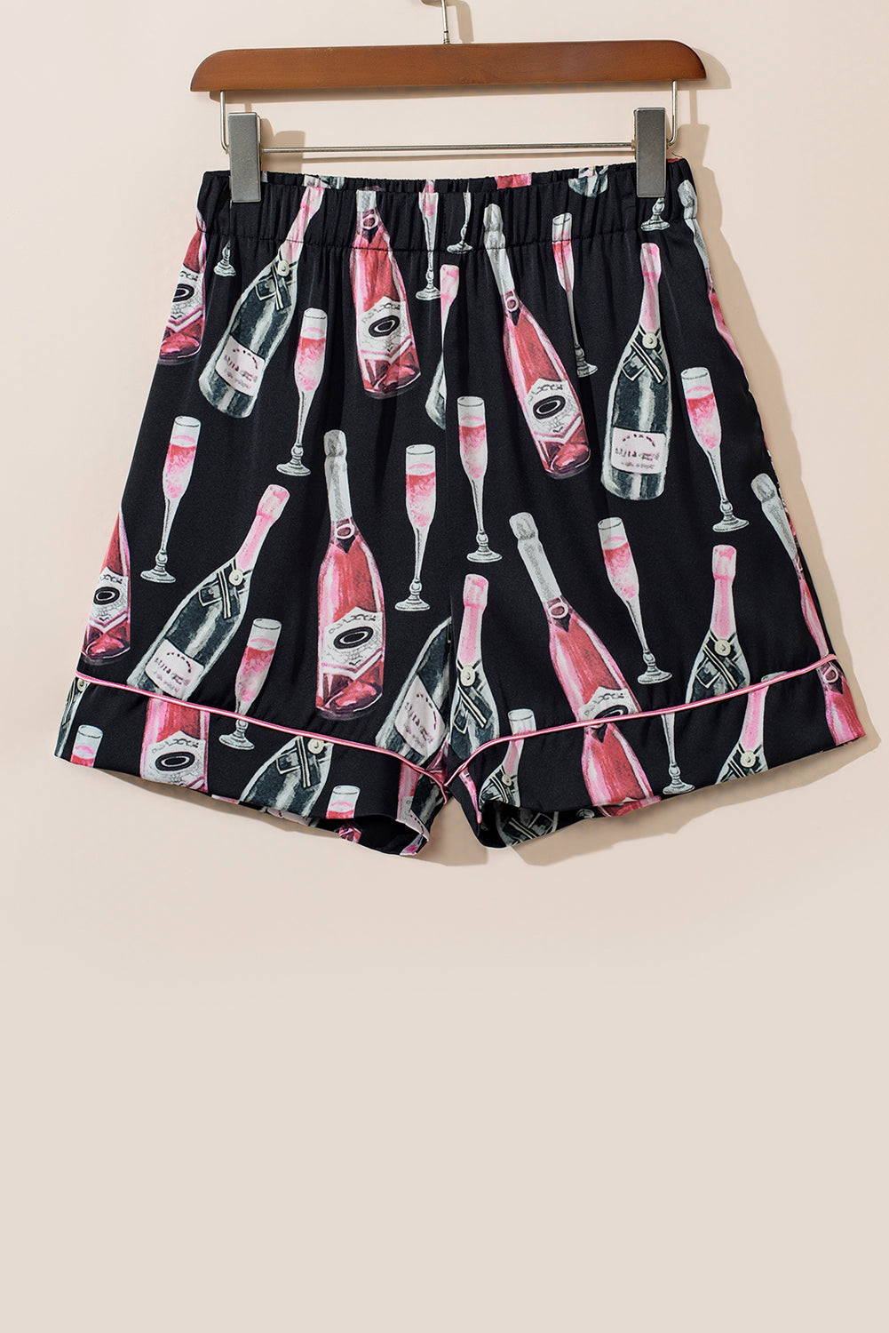 Black silk pajama shorts with champagne bottle and glass print, pink piping detail.