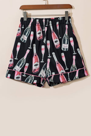 Black silk pajama shorts with champagne bottle and glass print, pink piping detail.