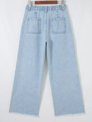 Light wash denim wide-leg jeans with studded side slits and raw hem.