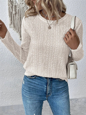 White long sleeve knit top with geometric eyelet pattern and crew neck.