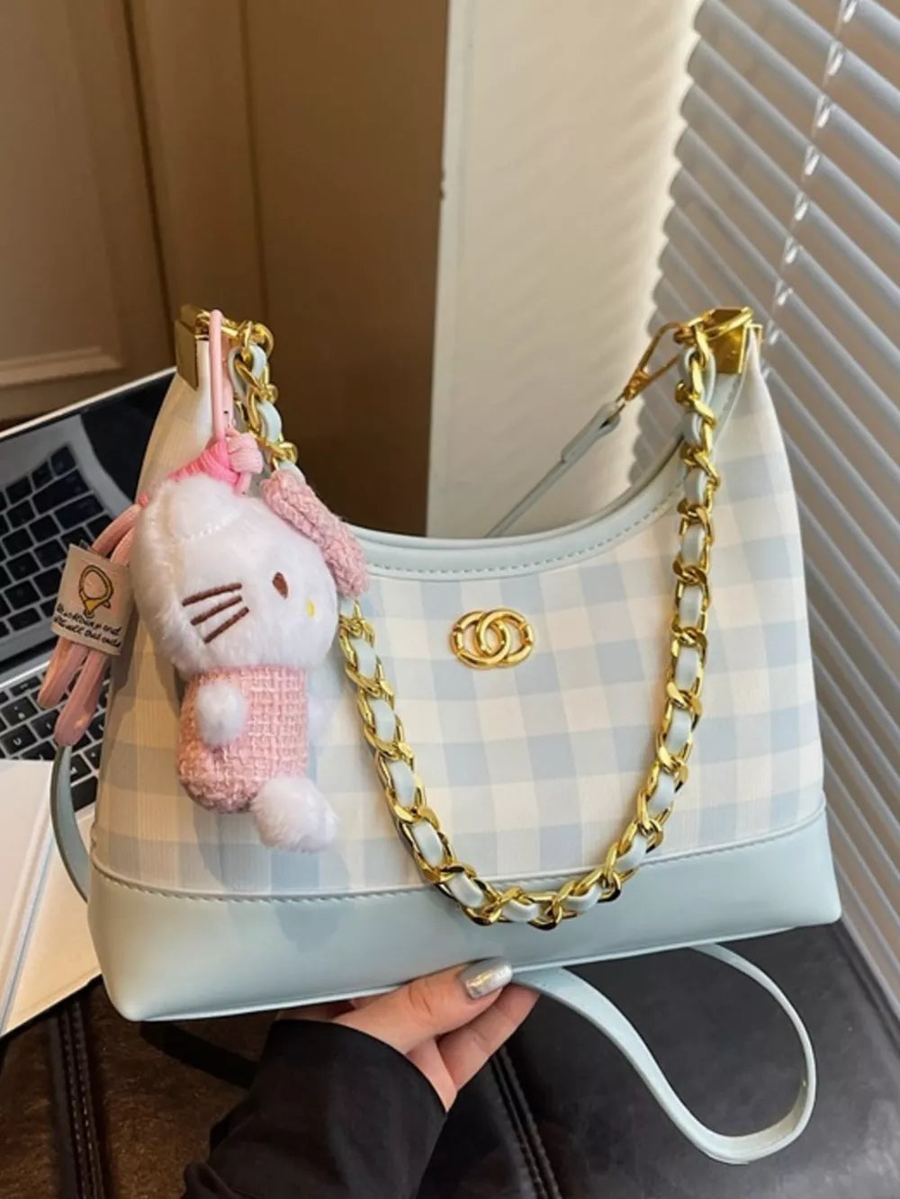 Pastel blue plaid shoulder bag with chain accent and Hello Kitty charm