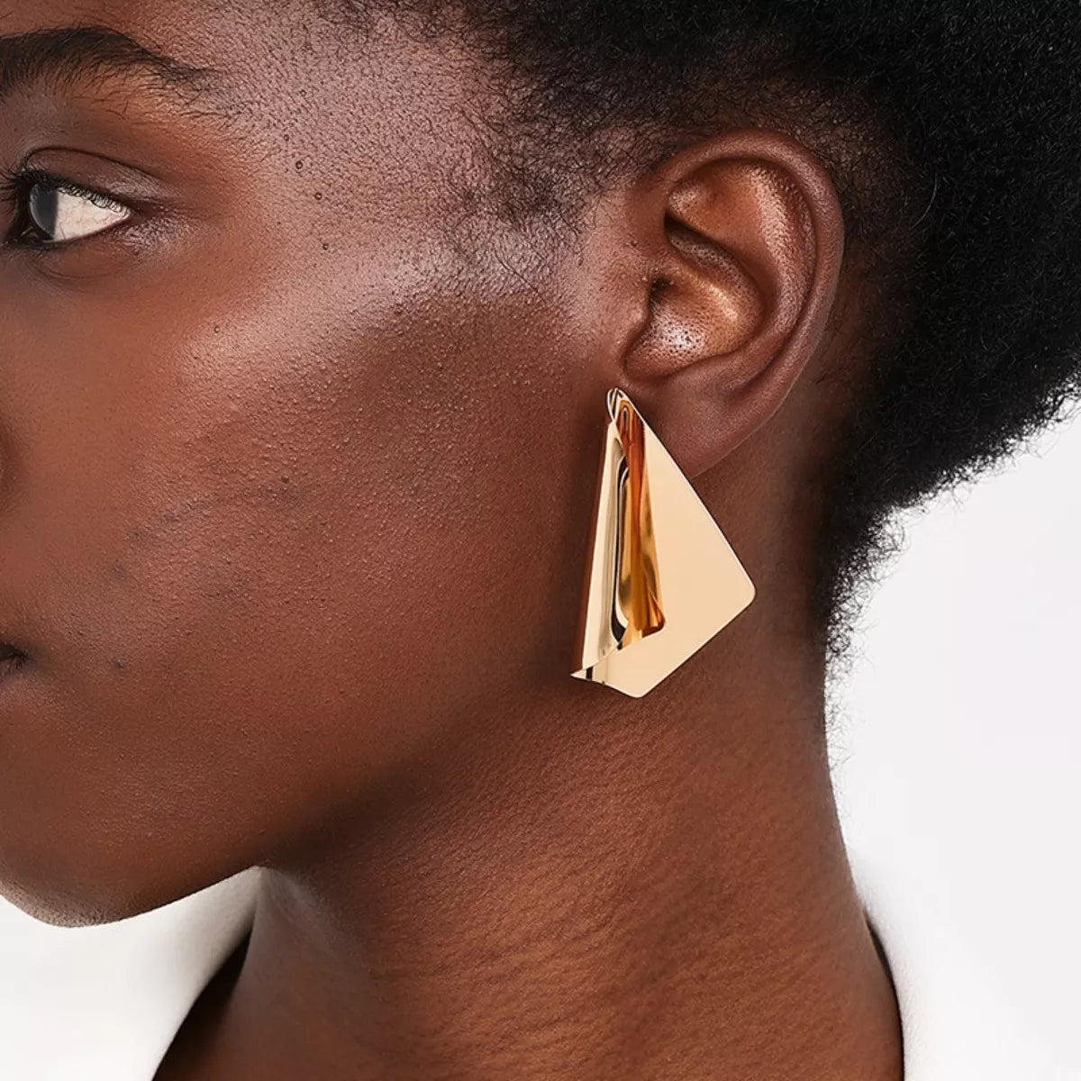 Sculptural triangle earrings in gold, featuring a modern, angular design.