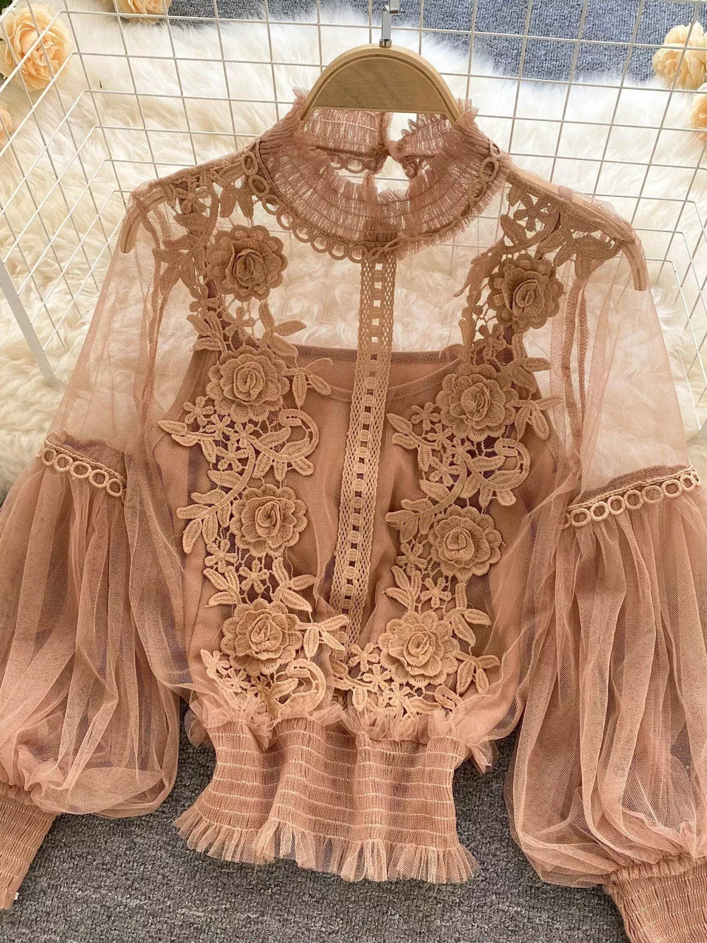 Light brown embroidered lace blouse with sheer puff sleeves and ruffled hem, worn over a cami.