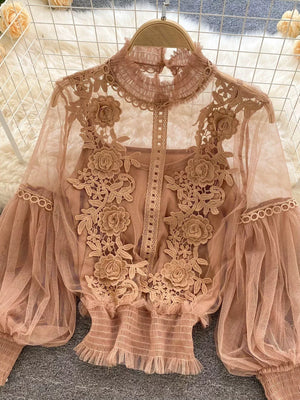 Light brown embroidered lace blouse with sheer puff sleeves and ruffled hem, worn over a cami.