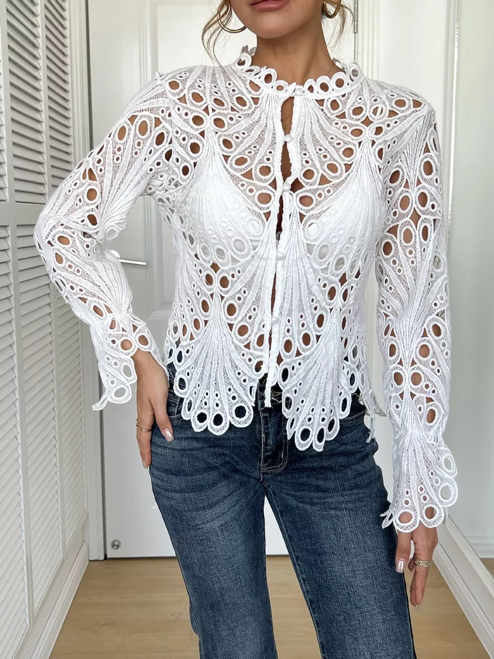 White lace button-up blouse with scalloped collar and bell sleeves.