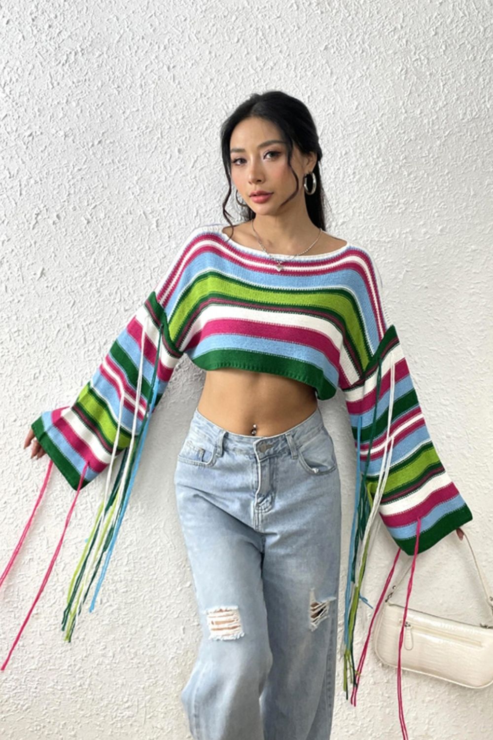Cropped knit sweater with multicolor stripes and fringe sleeves.