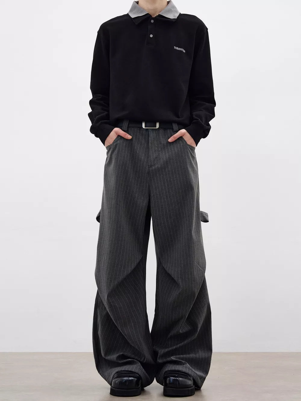 Men's grey pinstripe wide-leg sweatpants with pockets and a relaxed fit.