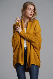 Mustard acrylic cocoon knit sleeve cardigan with textured sleeves and ribbed cuffs.