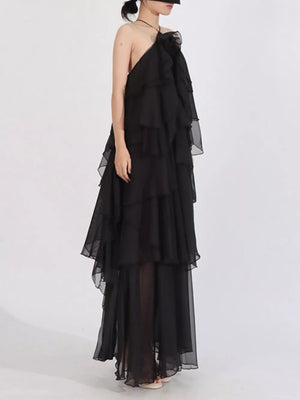 Black cascading ruffle halter maxi dress with tiered skirt detail.