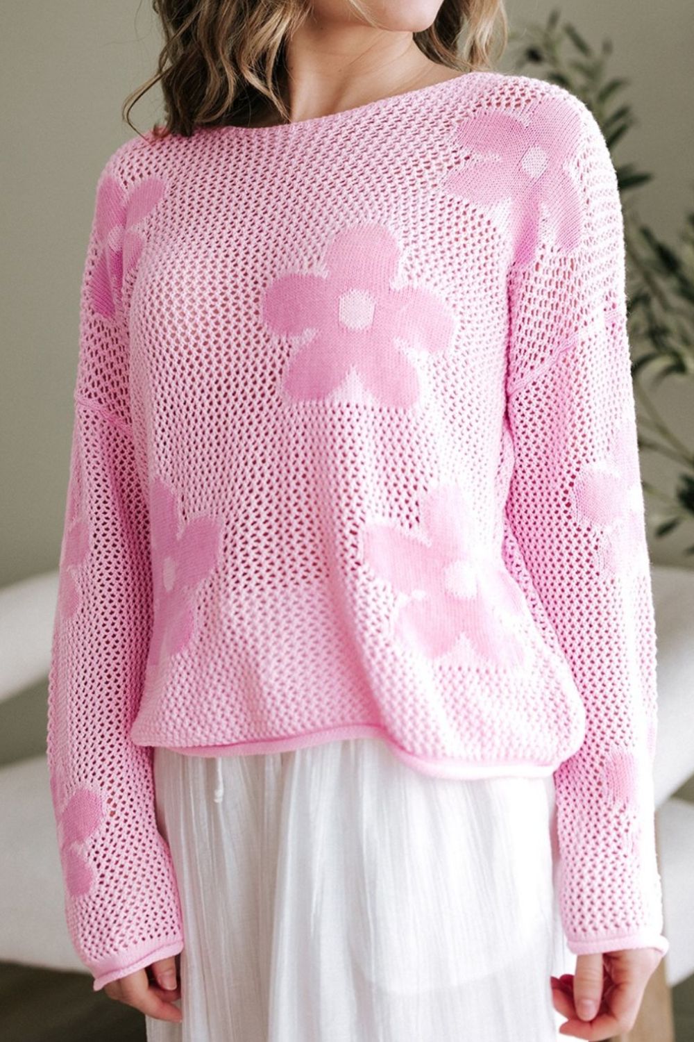 Openwork blush pink acrylic sweater with floral intarsia pattern and crew neck.