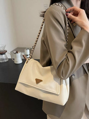 Off-white shoulder bag with flap, chain detail, and triangle logo.