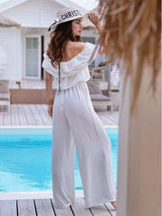 White off-shoulder ruffle palazzo jumpsuit with wide legs.