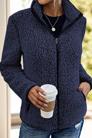 Navy teddy fleece zip-up jacket with black trim and zipper detail