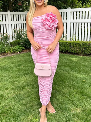 Pink ruched bodycon midi dress with floral appliqué and one-shoulder neckline.