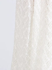 White lace maxi dress detail showing intricate diamond pattern fabric.
