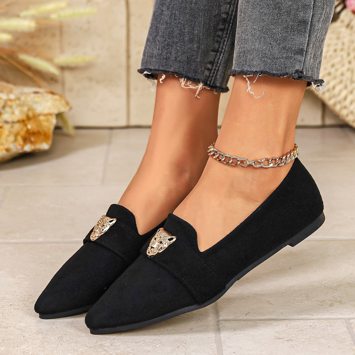 Black slip-on flats with pointed toe and gold leopard detail.
