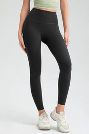 Black high rise leggings with a seamless waistband and athletic shoes