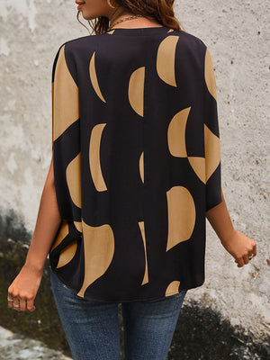 Black abstract print batwing blouse with wide sleeves and a relaxed fit.