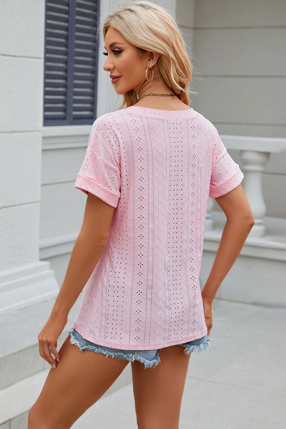 Pink perforated pocket tee with rolled sleeves and a casual fit.