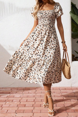 Tiered ruffle sleeve midi dress with abstract print, smocked bodice, and tiered skirt.