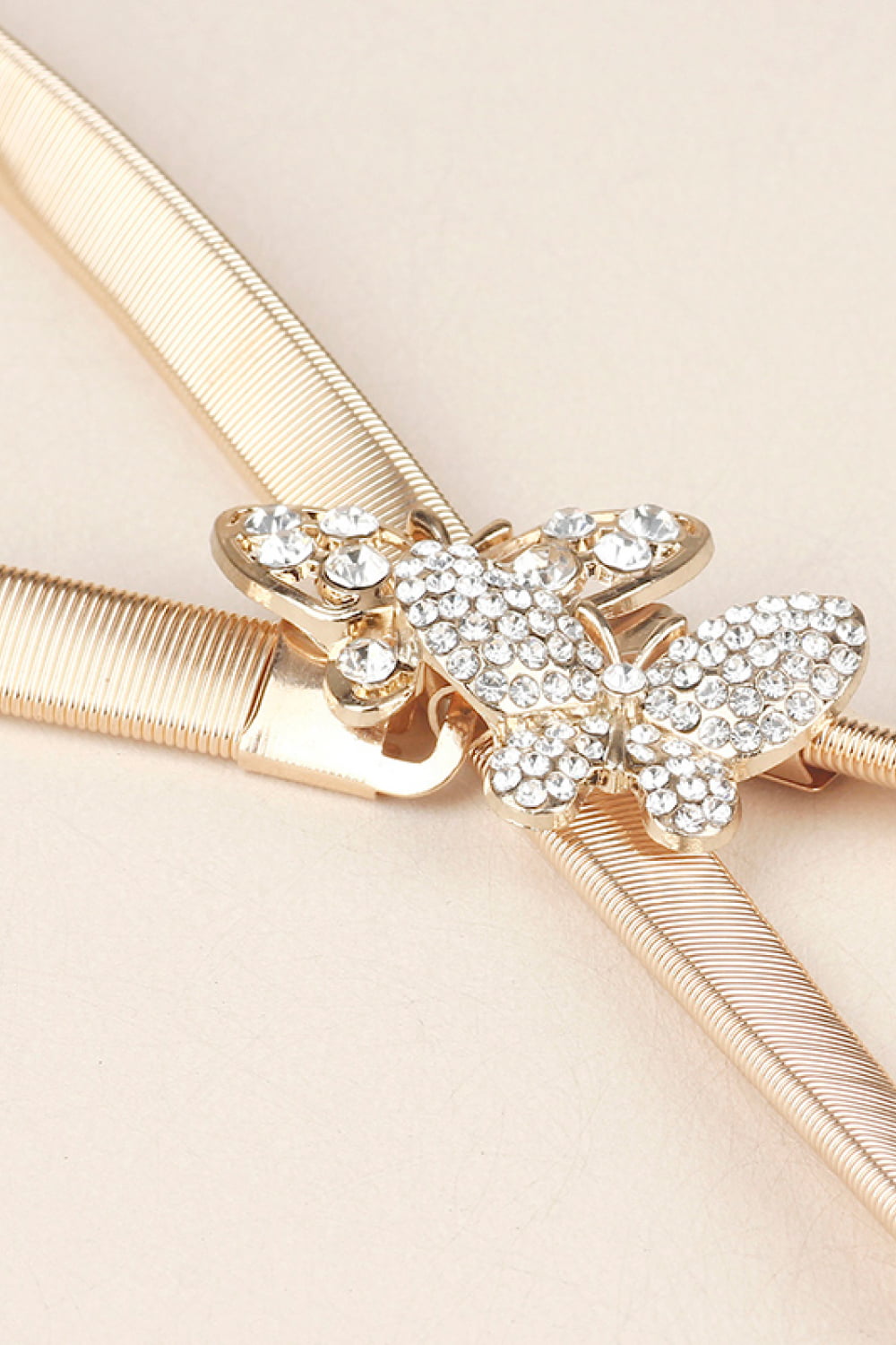 Gold elastic belt with a crystal-embellished butterfly clasp