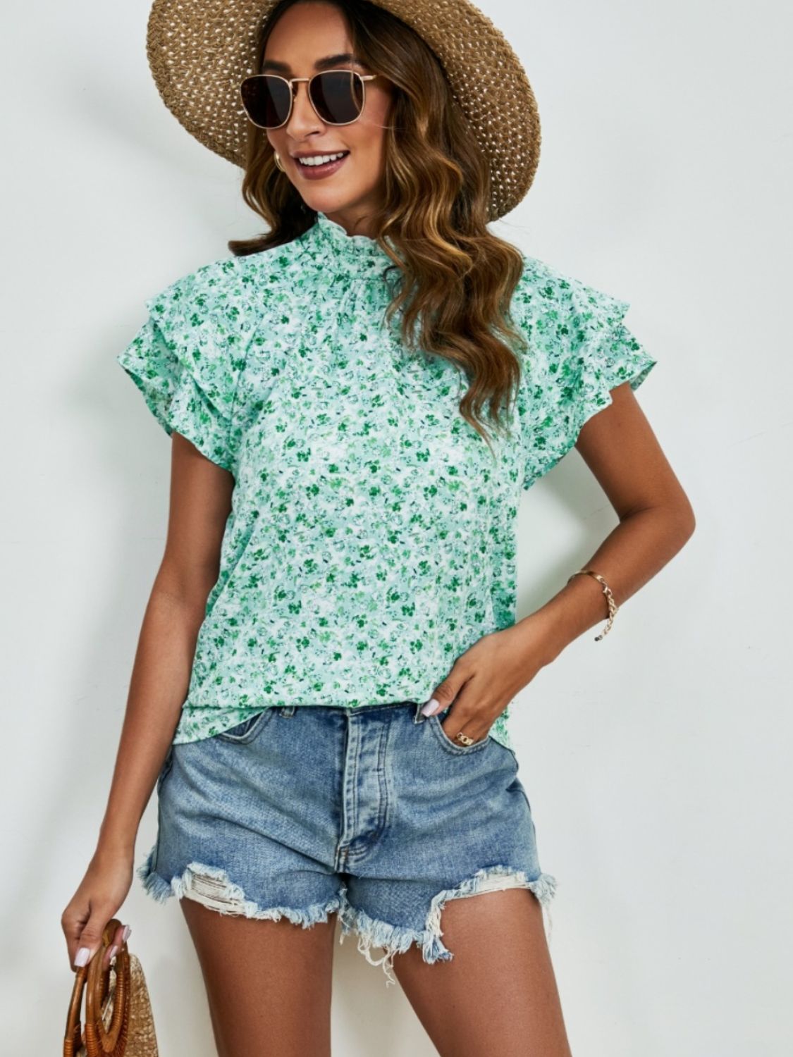 Light green floral blouse with ruffled neckline and flutter sleeves.
