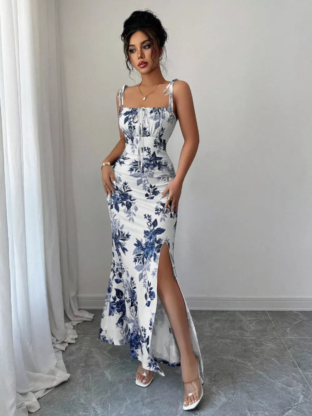 Maxi dress in Peacock Blue floral print with tie straps, ruched bodice, and high slit.