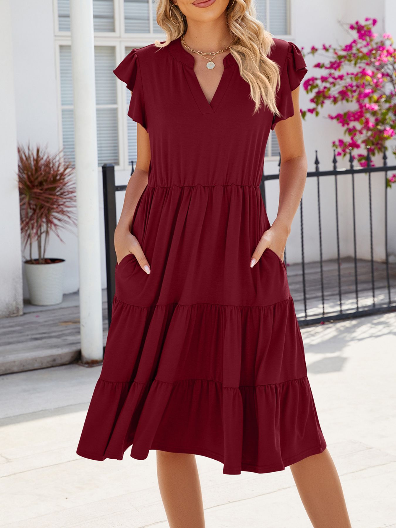 Burgundy ruffled midi dress with notched V-neck, elastic waist, and pockets.