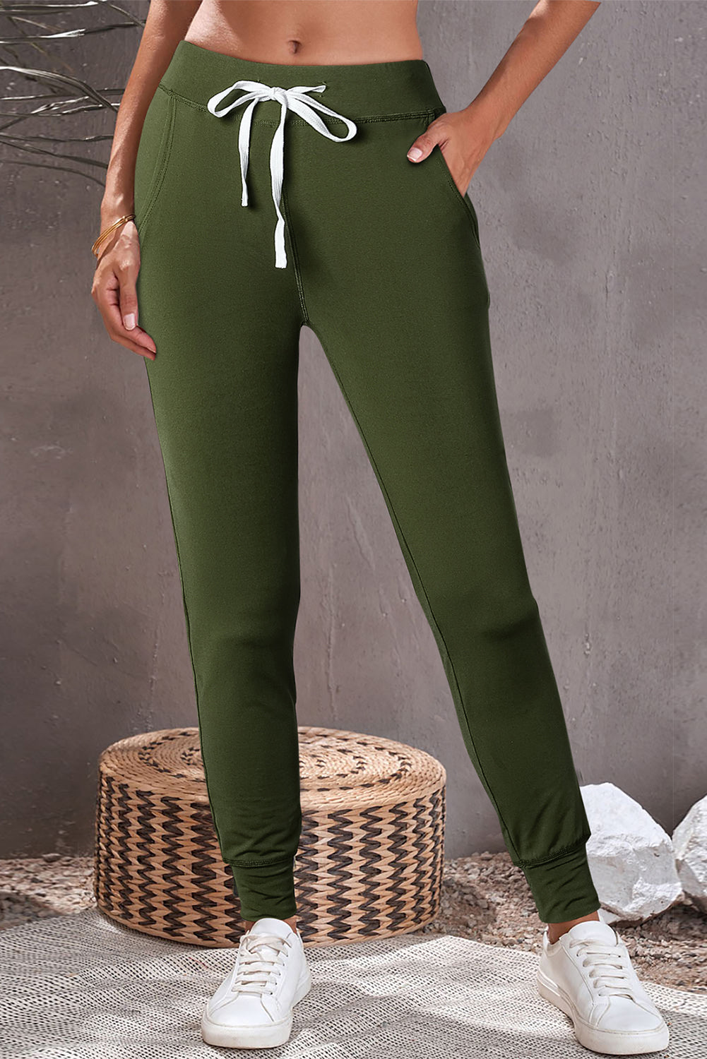 Slim-fit army green joggers with white drawstring and pockets