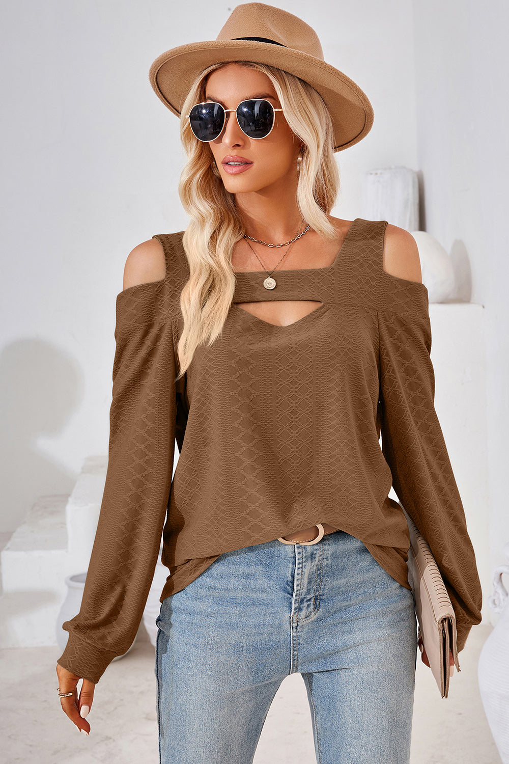 Brown geometric cutout shoulder top with a v-neck and long sleeves.