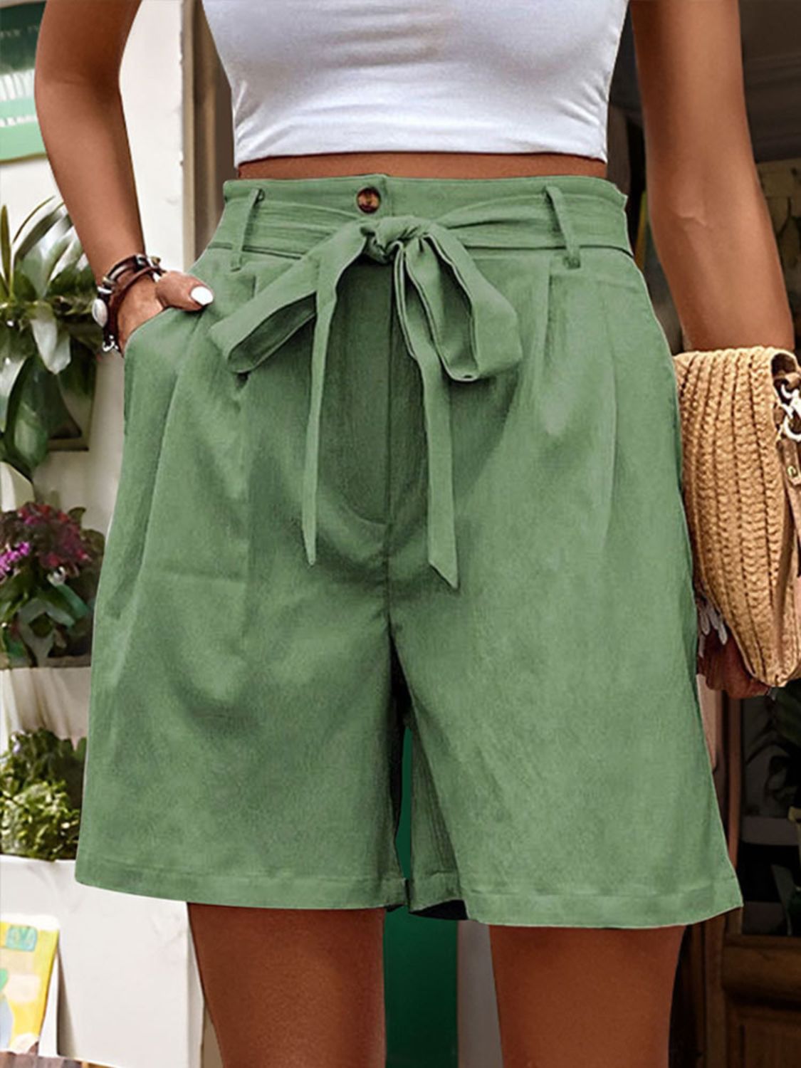 Matcha green linen bermuda shorts with tie waist and pleats.