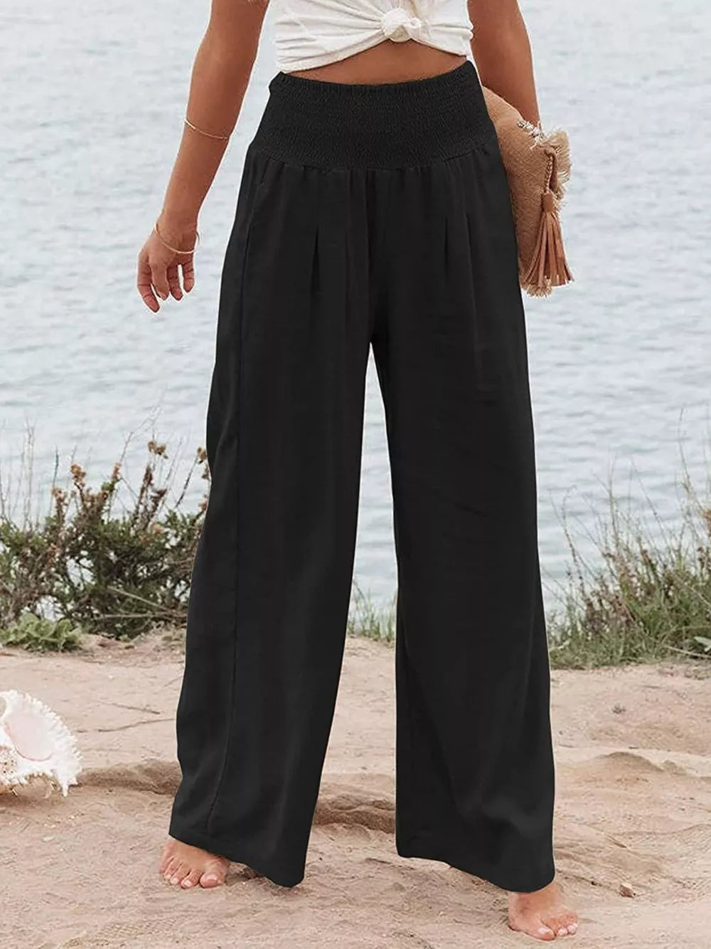 Black smocked wide-leg maternity pants with a relaxed fit and flowy silhouette.