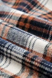 Sherpa-lined plaid overshirt jacket in dark blue, black, and tangerine plaid with button details.