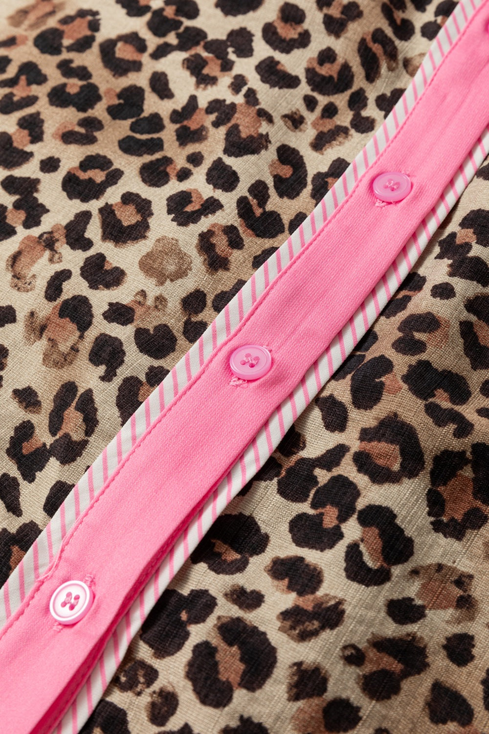 Print short sleeve shirt with leopard pattern and pink button placket detail.