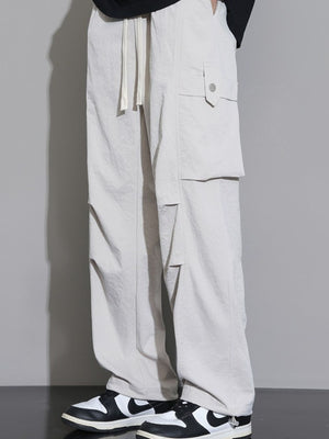 Men's relaxed fit cargo sweatpants in light gray with drawstring waist and button flap pockets.