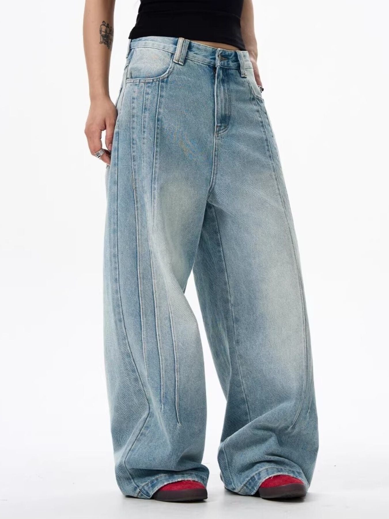 Men's light blue washed denim wide leg jeans with vertical seam details.