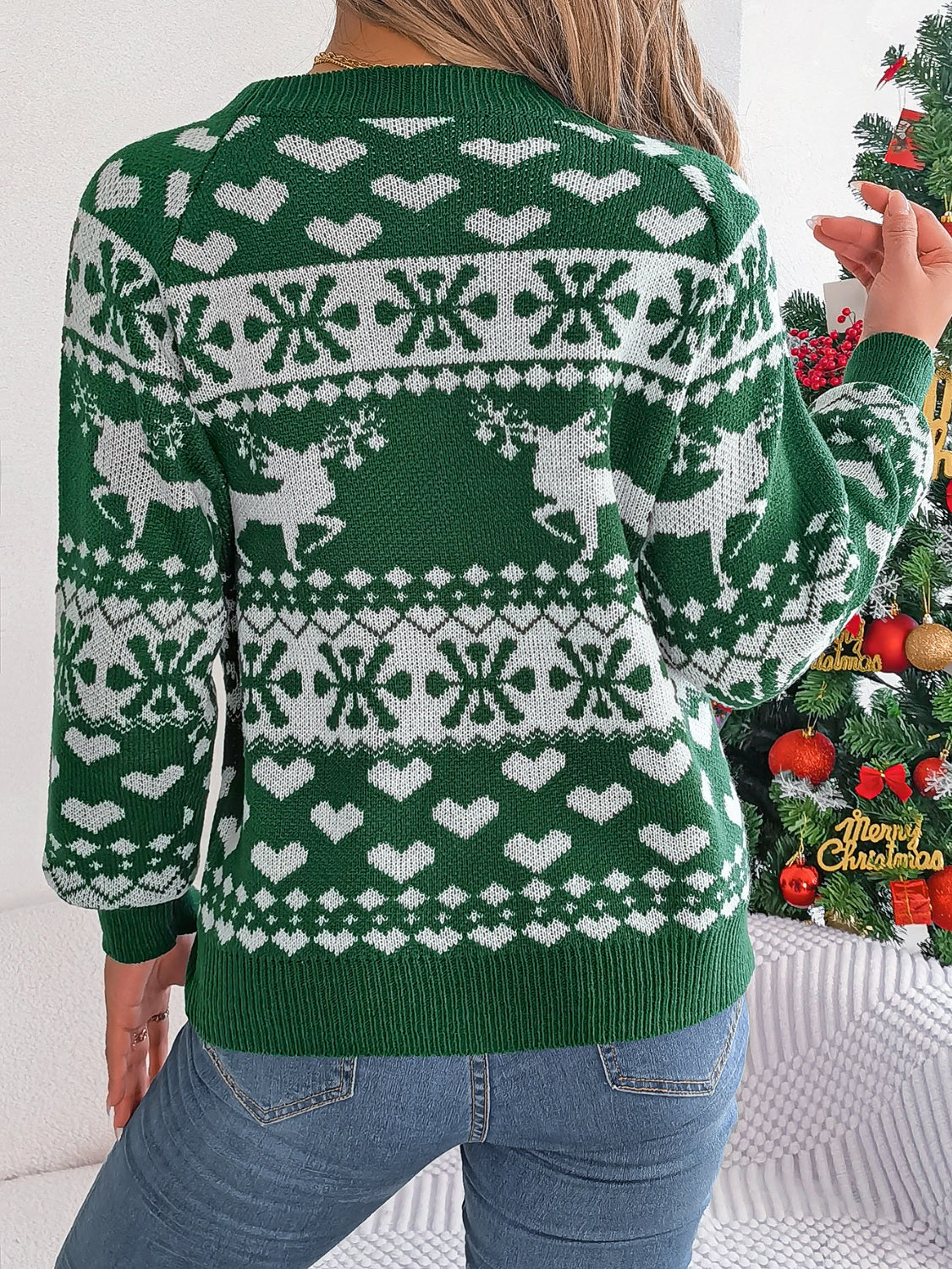 Green acrylic sweater with white reindeer, snowflake, and heart jacquard pattern.