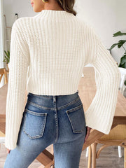 White ribbed crop sweater with bell sleeves and mock neck, styled with jeans.