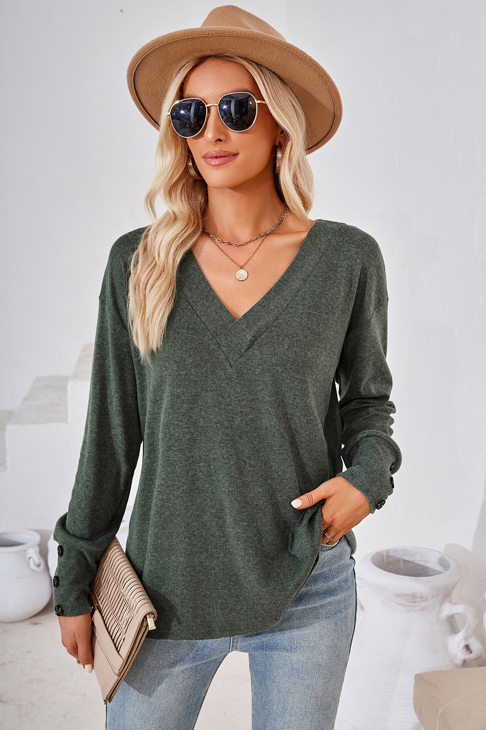Dark green V-neck top with button cuffs and a slouchy fit.