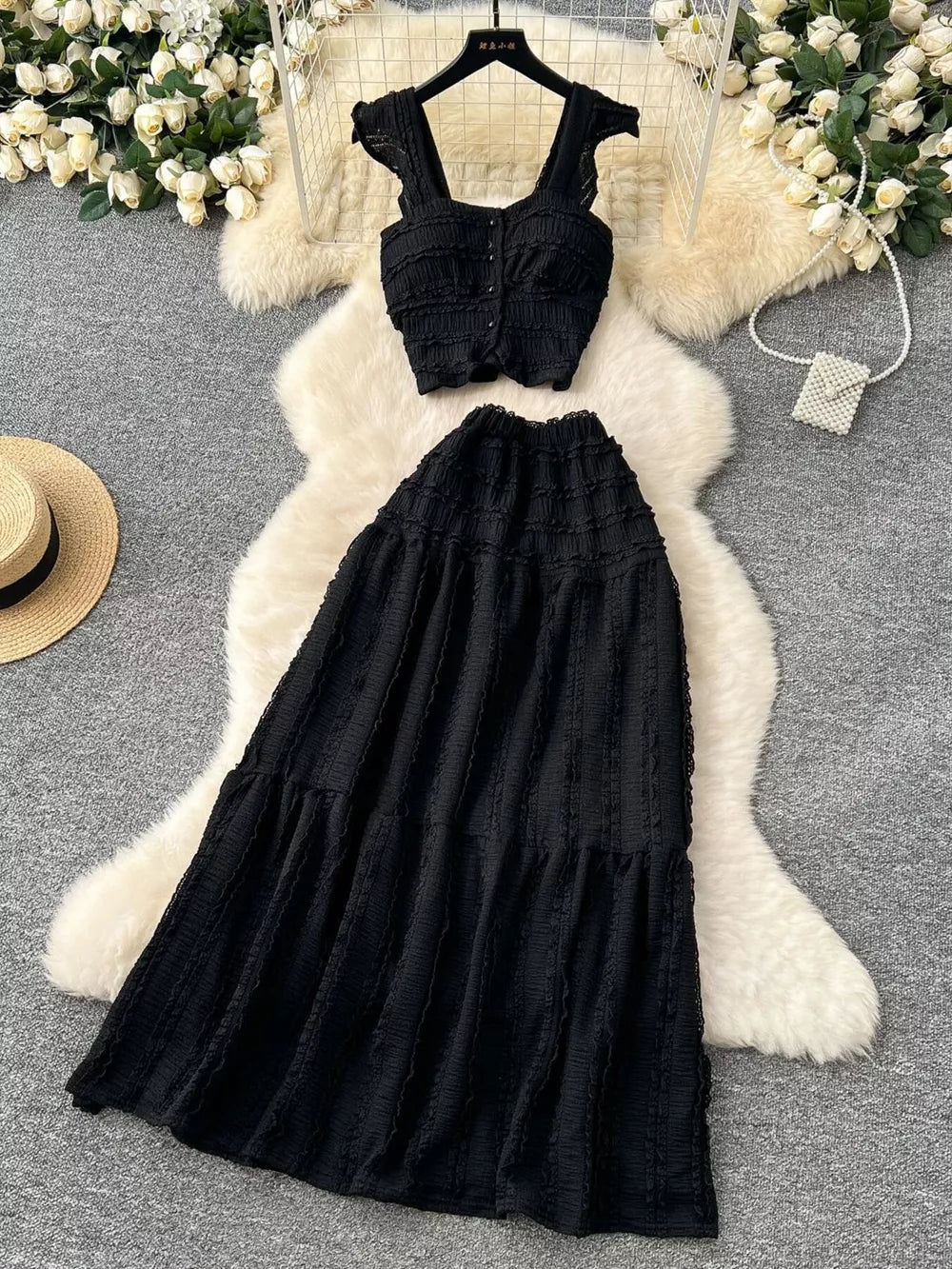 Black textured two-piece set with ruffled crop top and tiered maxi skirt.