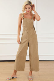 Tan corduroy overalls with wide leg silhouette and buttoned straps.