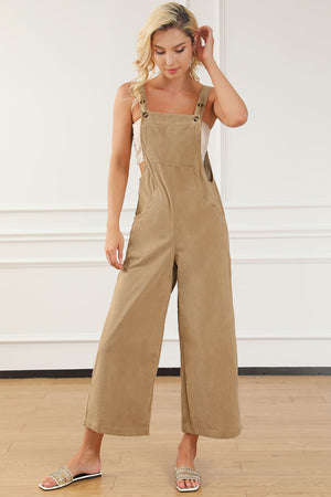 Tan corduroy overalls with wide leg silhouette and buttoned straps.