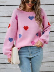 Pink acrylic knit sweater with bubble sleeves and a scattered heart motif.