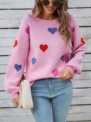 Pink acrylic knit sweater with bubble sleeves and a scattered heart motif.