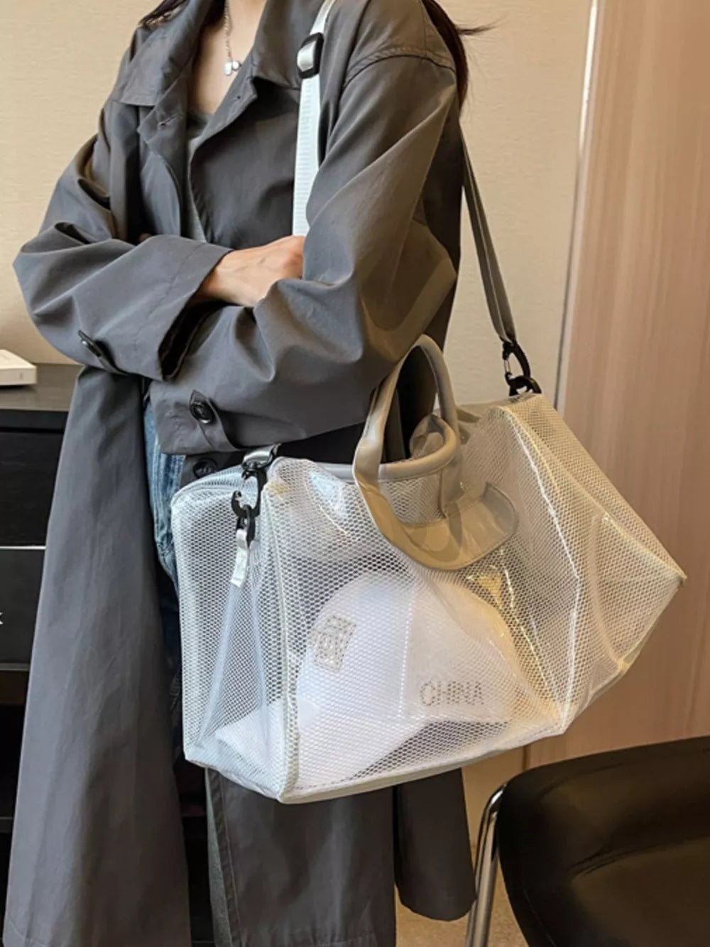 Vibrant transparent mesh travel bag with white cap inside, light gray handles and strap.
